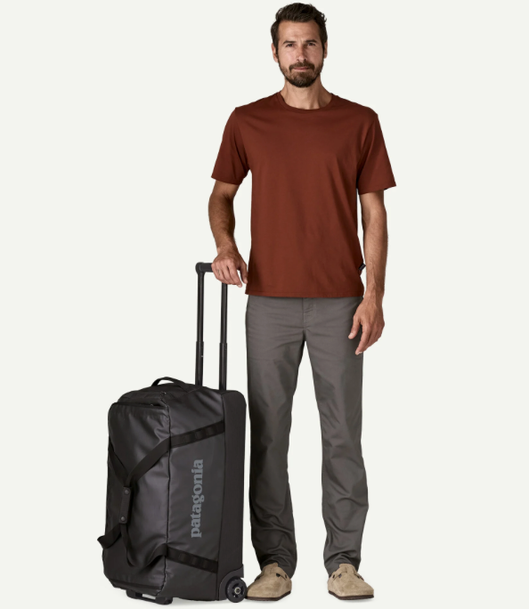 Man Holding Patagonia Unisex Black Hole® Wheeled Duffel Travel Bag-Black
