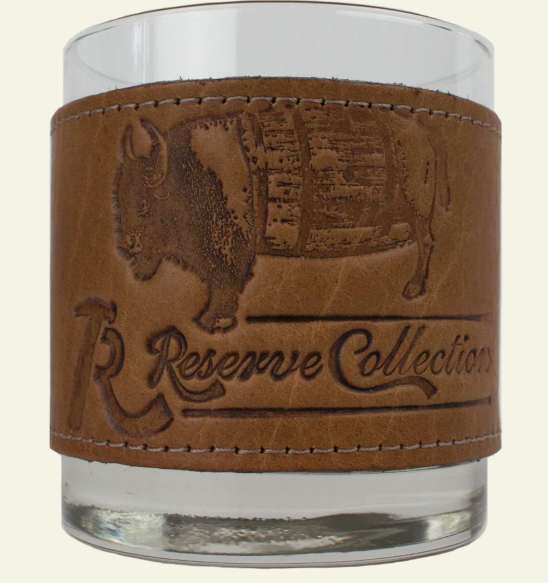 Over Under Bison Wrapped Bourbon Leather Grip Glassware with a brown leather sleeve featuring a buffalo design and 'R&G Reserve Collection' text on a beige background.