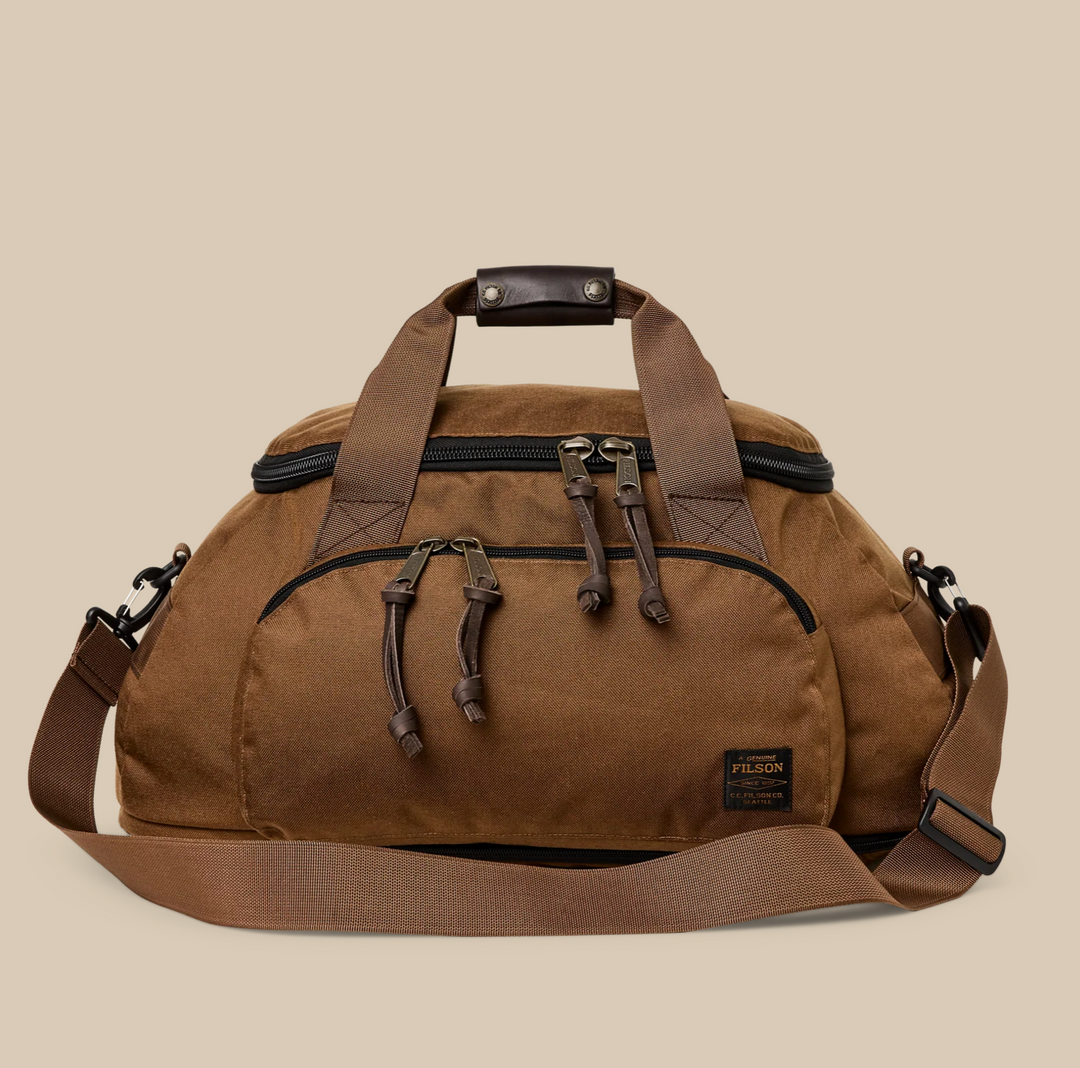 Filson Dryden Duffle Pack in tan with zippered compartments, leather accents, and convertible duffle‑to‑backpack straps.