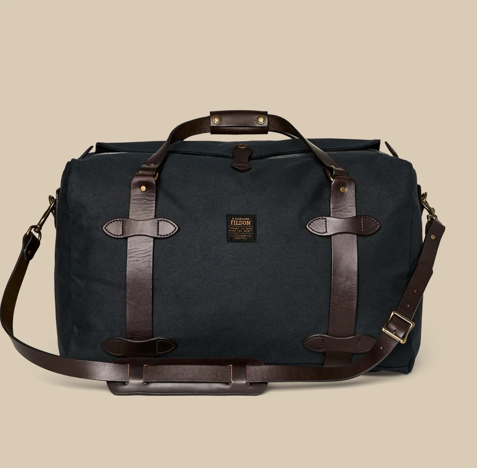 Filson Rugged Twill Medium Duffle Waterproof Leather Back Pack in black with zippered compartments, leather accents, and convertible duffle‑to‑backpack straps.