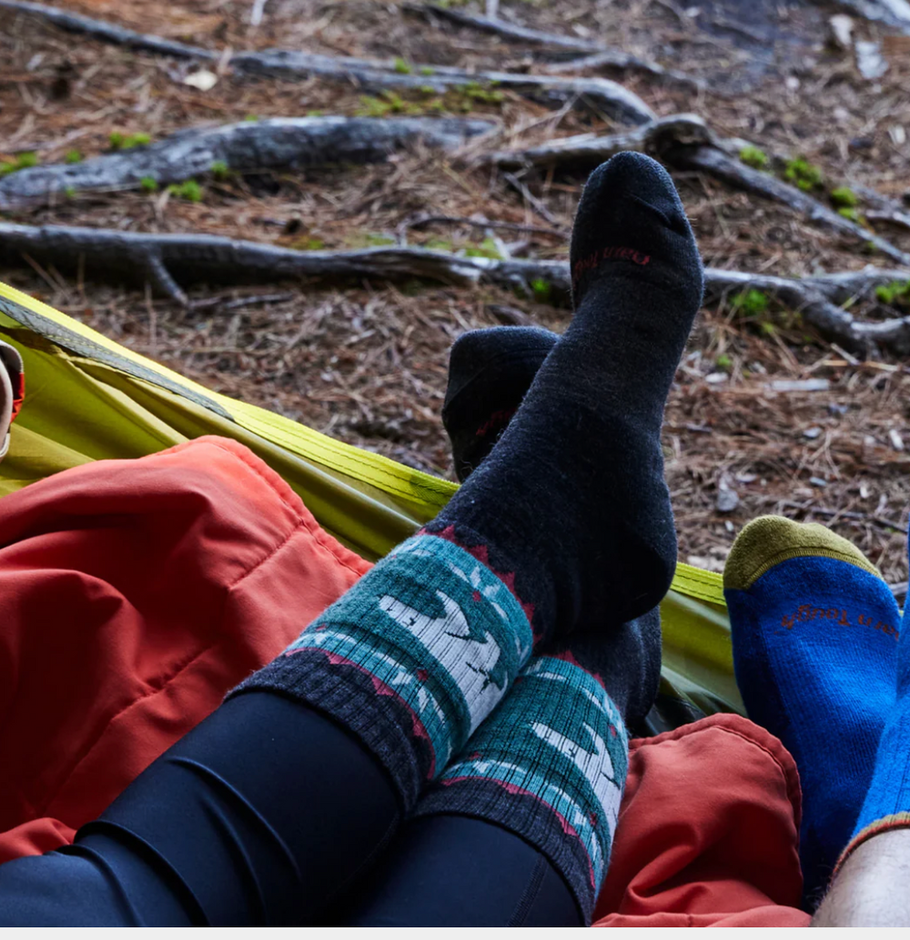 Woman wearing Darn Tough Vanna Grizzle Hiking Socks with boots on a trail, showcasing durable comfort and performance fit for outdoor adventures.