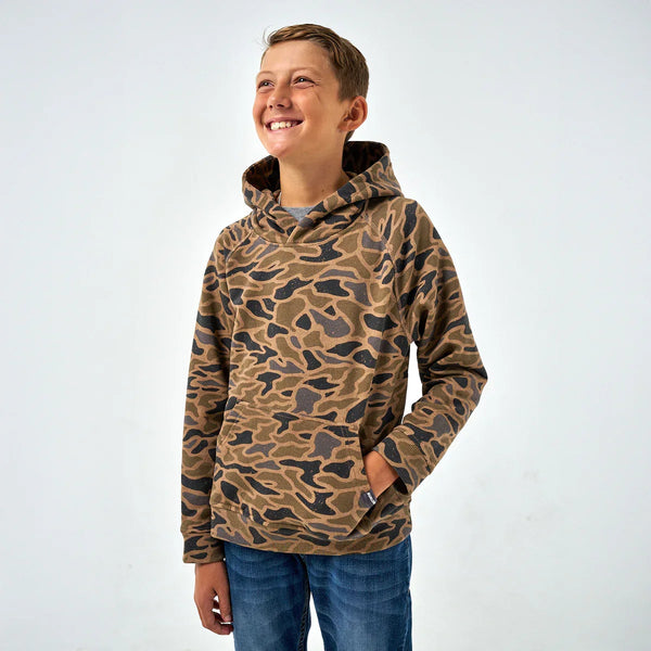 Boy wearing Burlebo Youth Fleece Camo Hoodie outdoors, showcasing cozy warmth and casual everyday style.